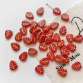 Detailed macro view of red leaf-shaped glass beads with gold veins for DIY jewelry - 5-Pack / Red