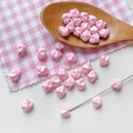 Detalle macro de cuentas rosadas irregulares con brillo perlado para bisutería DIY - Rosa