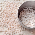 Macro detail of 4mm creamy pink glass seed beads for DIY jewelry and beaded crafts - 10 g / Light Pink