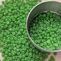 Detailed macro view of 4mm green glass seed beads for DIY jewelry making and crafts - 10 g / Green