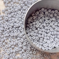 Detailed macro view of 4mm light gray glass seed beads for DIY jewelry making and crafts - 10 g / Gray