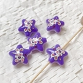 Dettaglio di perline acriliche viola a forma di stella con stampe di coniglio per fai da te - Viola