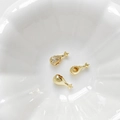 Dettaglio macro di ciondoli a coscia di pollo placcati in oro 18k con zirconi per DIY - Oro 18K