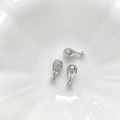 Dettaglio macro di boccole per perle a forma di coscia argentata con zirconi per bigiotteria - Oro Bianco