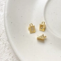 Detailed view of gold-plated mini suitcase and cheese charms with sparkling zircon stones - 18K Gold Triangle Cheese