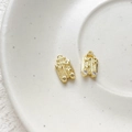 Macro detail of gold-plated suitcase charms with heart relief and zircon wheels - 18K Gold Suitcase