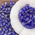 Macro detail of cobalt blue glass tulip beads with gold accents in a ceramic bowl - Gold Traced Tulip (7#) / 1 Piece / Dark Blue