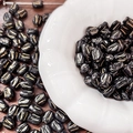 Close-up of black glass tulip beads with gold details on a decorative white dish - Gold Traced Tulip (11#) / 1 Piece / Black