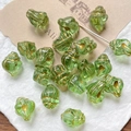 Macro shot of green shell-shaped glass beads with gold lining for DIY jewelry making - Clear Green