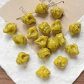 Macro view of vintage ginger conch glass beads with gold painted texture for DIY jewelry - Earthy Yellow