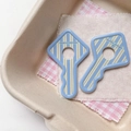 Detailed close-up of acrylic key-shaped pendants with blue stripes and a friendly slogan - Blue