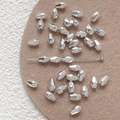 Macro detail of faceted silver metal beads with central hole for DIY jewelry making - White