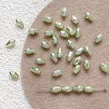 Close-up of faceted light green glass beads for DIY jewelry making and handmade crafts - Green
