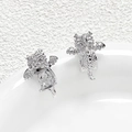 Macro shot of silver dragon earrings with sparkling cubic zirconia on white ceramic tray - Platinum Plated Style / Silver