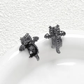 Macro detail of black metal dragon charms with intricate scale textures on white ceramic - Gun Black Plated Style / Gunmetal