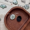 Macro shot of 18mm resin bamboo leaf charms with pearlescent finish and traditional shapes - Hexagon Style