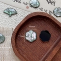 Macro detail of mother-of-pearl shell charms with green bamboo ink painting - Plum Blossom Style