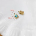 Détail d'un pendentif rectangulaire doré 14x8mm serti d'une pierre turquoise bleue brillante - Rectangle Pierre Bleu Ciel