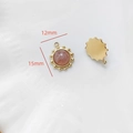 Vue macro de pendentifs soleil dorés 15mm avec pierre rose pour la création de bijoux DIY - Quartz Fraise Dentelle Ronde