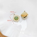 Vue macro d'un pendentif doré vintage de 18mm avec pierre verte et reliefs - Losange Pierre Verte Bordure Vintage