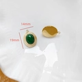 Vue macro du pendentif ovale serti d'une pierre verte de 19x14mm avec monture dorée - Ovale Pierre Verte Bordure