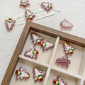 Close-up of hand-painted glass Christmas tree beads for DIY jewelry and phone charms - Purple