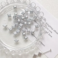 Macro shot of silver matte star beads on a glass tray for DIY jewelry making accessories - Silver