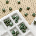Macro detail of green pumpkin-shaped glass beads for DIY jewelry making in a ceramic tray - Green Pumpkin Style (4#)