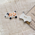 Macro shot of hand-painted ceramic dalmatian-shaped buttons with orange spots for DIY sewing - Style 4