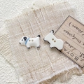 Macro detail of hand-painted dalmatian ceramic beads with two holes for DIY jewelry making - Style 9
