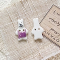 Detailed close-up of handmade ceramic bear-shaped beads with a purple vest and two-hole design - Style 11
