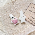 Macro shot of hand-painted ceramic rabbit buttons showing front design and back dual holes - Style 13