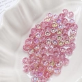 Detailed view of pink daisy glass beads for DIY jewelry making in a white shell tray - Holographic Pink (4#)