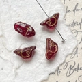 Macro detail of bird-shaped deep red glass beads with gold textured engravings - Opaque Dark Red Bird (11#)