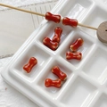 Detailed macro view of bone-shaped red ceramic beads for DIY jewelry making - 4# Red Kiln Changed Style (D5347) / 1 Piece