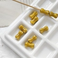 Macro detail of bone-shaped ceramic beads with speckled glaze in a ceramic tray - 6# Yellow Brown Spotted Style (D5347) / 1 Piece