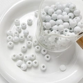 Close-up of glossy white ceramic beads for DIY jewelry making in a glass beaker - Style 3 (8mm/10 Pieces/Pack)