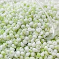 Macro detail of 4mm cream glass beads with green marble texture and gold speckles for DIY - 10g Pack / Color 4 (Green and White Ink Splash)