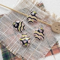 Detailed view of four handmade ceramic tropical fish beads on rustic linen background - 8# (Pink Black Green Stripes)