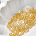 Macro detail of amber fish-shaped Czech glass beads with engraved scales for DIY jewelry - Amber