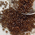 Macro shot of dark brown translucent glass seed beads scattered on vintage newspaper - 3# / 10 Pieces Pack