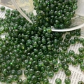 Macro shot of transparent dark green Czech glass beads pouring from a glass bowl - Size 6 / 10 Pieces Pack