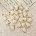 Macro view of bell-shaped cream Czech glass beads with golden stripes for DIY jewelry - Cream Style (16#)