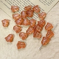 Macro shot of amber glass bell beads with grooved texture on a vintage paper background - Amber Style (21#)