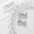 Detalle del conector de joyería de lazo plateado con pedrería y acabado texturizado para DIY - Transparente Base Plateada (D4898)