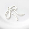 Detailopname van witte emaille strikhanger met metalen oogje voor DIY-sieraden - Wit