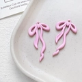 Dettaglio di ciondoli a fiocco rosa opaco per gioielli fai-da-te su vassoio ceramico - Rosa Tenue