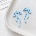Dettaglio macro di ciondoli a fiocco azzurro con anellini per creazione gioielli - Celeste