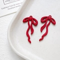Dettaglio di ciondoli a fiocco rosso per creazione gioielli su fondo in ceramica - rosso vivo