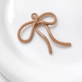 Macro-opname van camel emaille strik hanger op keramisch bord voor DIY-sieraden maken - camel
